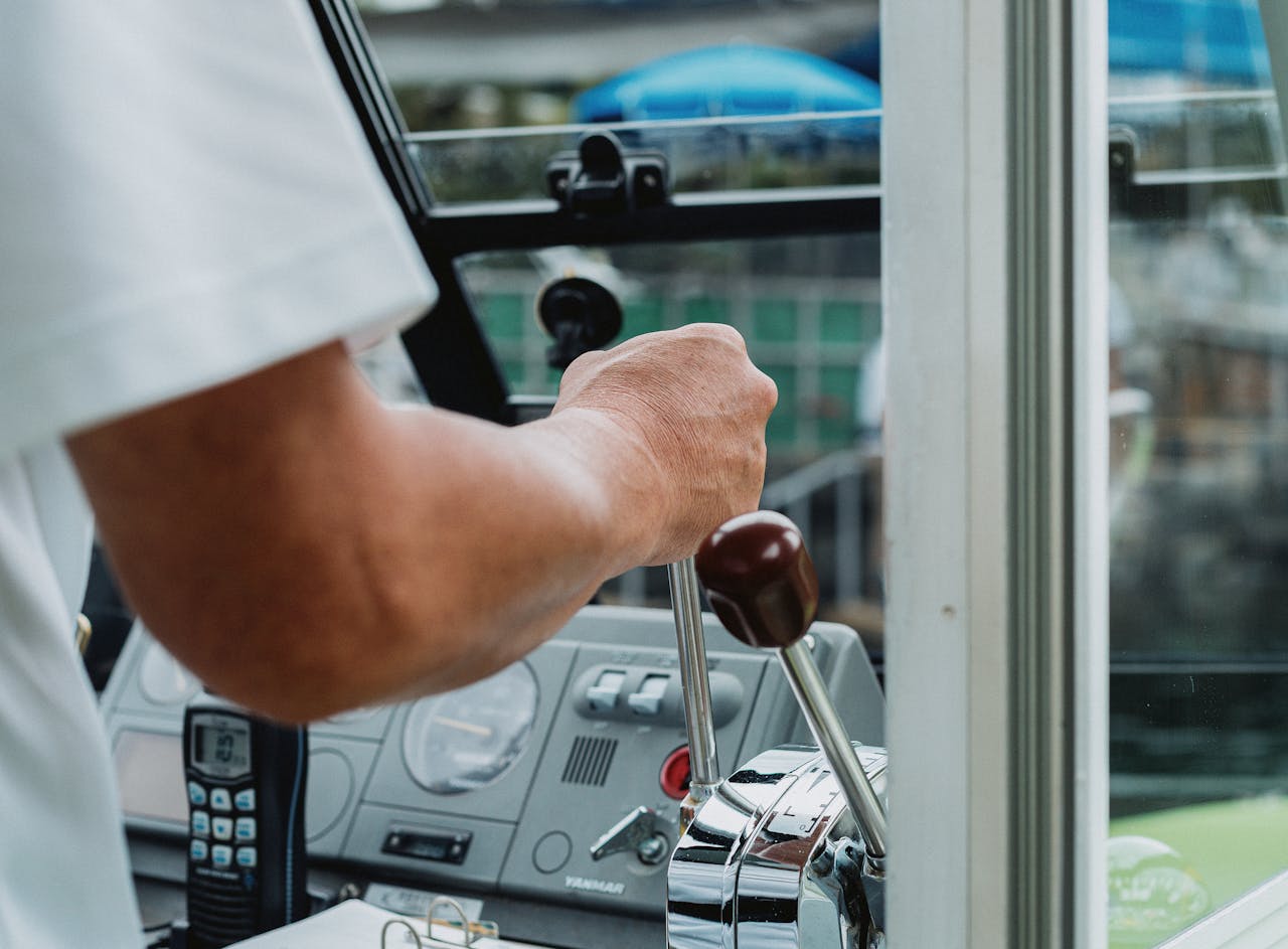 A detailed view of a person's hand controlling a boat steering in West Izu, Shizuoka, Japan.